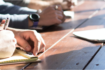 Writing in notepad - wooden table