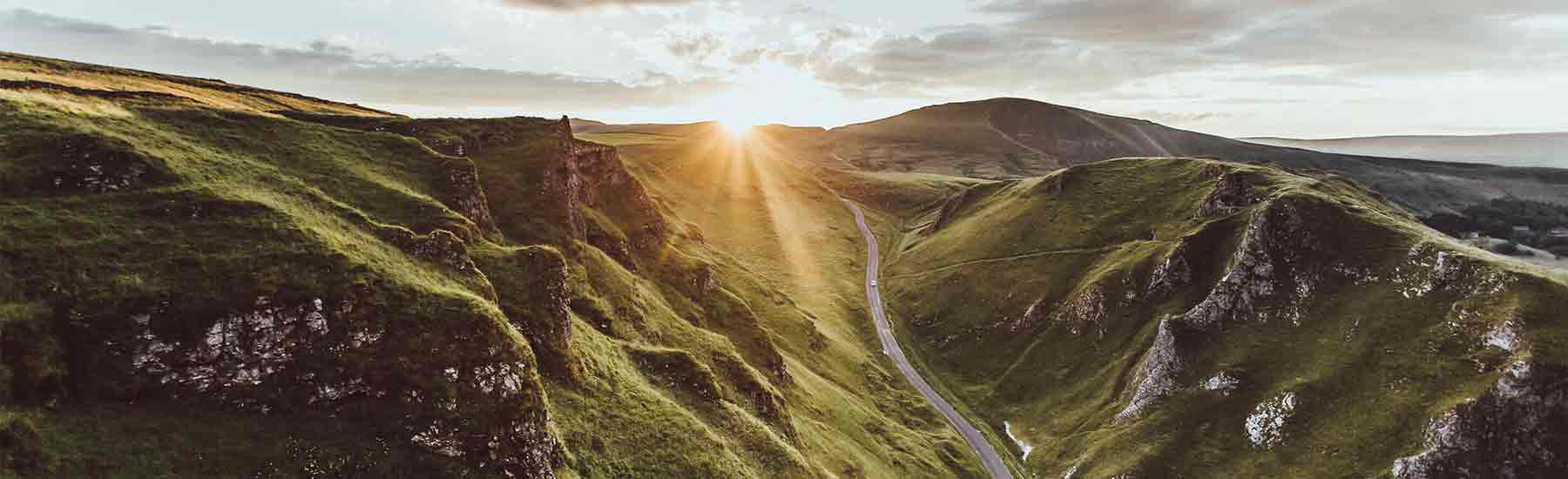 mountain road with a sunset in the background