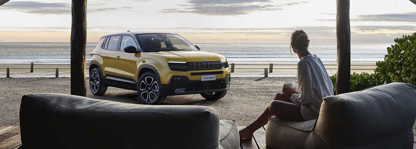 lady sitting on beach with jeep