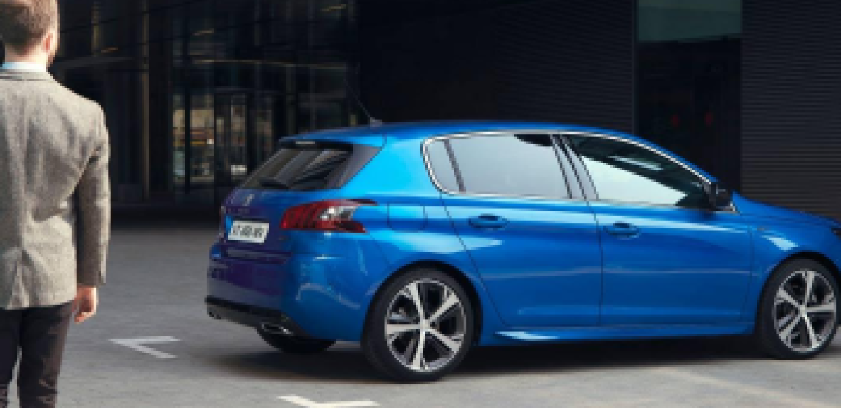 Man in suit looking at blue car