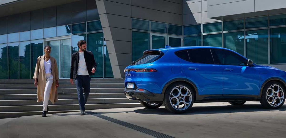 Couple walking away from Alfa Romeo Tonale in Blue