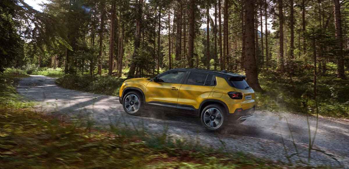 Yellow Jeep Avenger driving through forests of pine trees