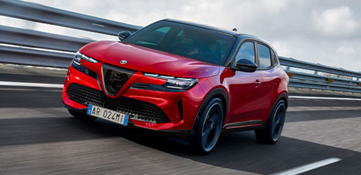 An Alfa Romeo Junior in Brera Red driving on a track.