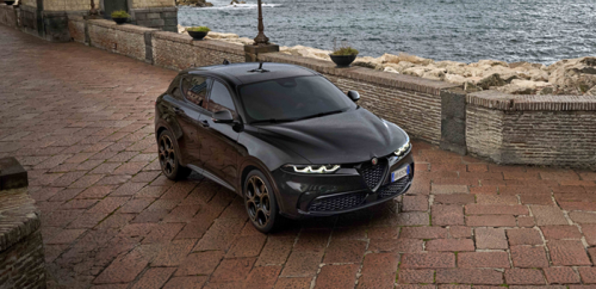 Front view of an Alfa Romeo Tonale in Alfa Black parked in front of the sea.