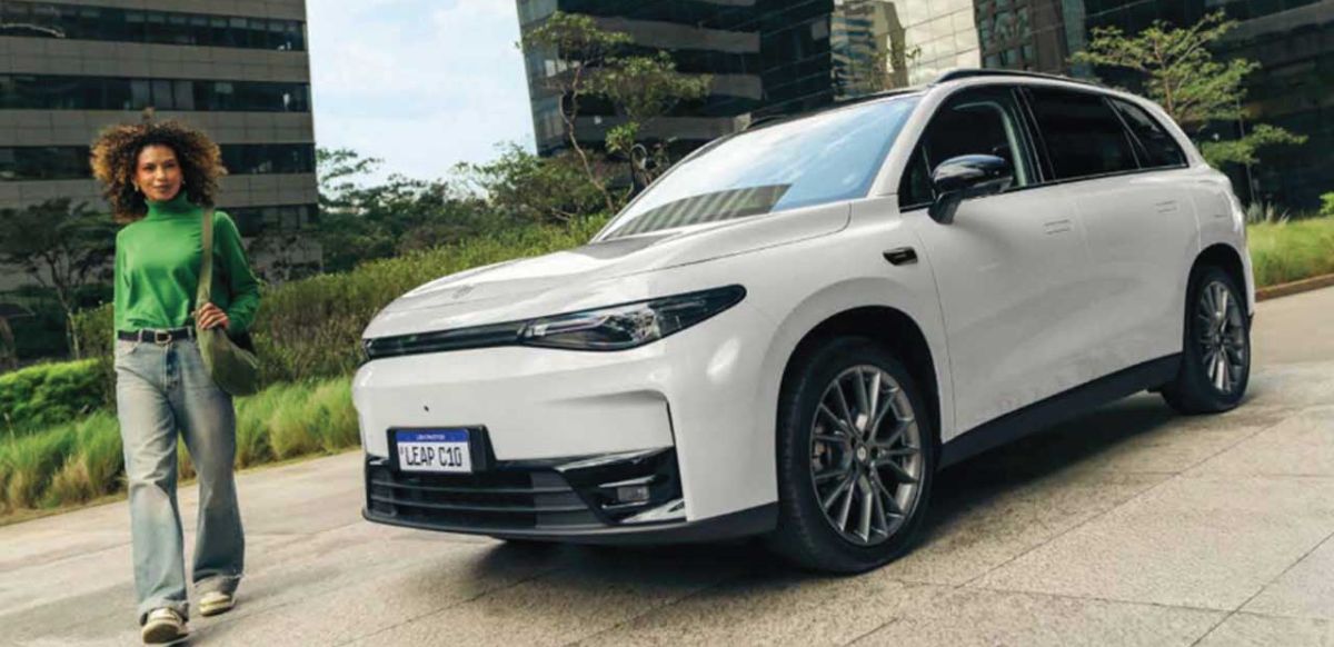 Leapmotor C10 electric SUV in Pearly White on a city street with modern architecture in the background.