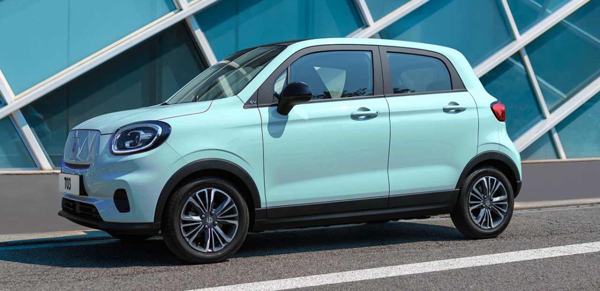 Caribbean Blue Leapmotor T03 electric hatchback parked outside a contemporary building.