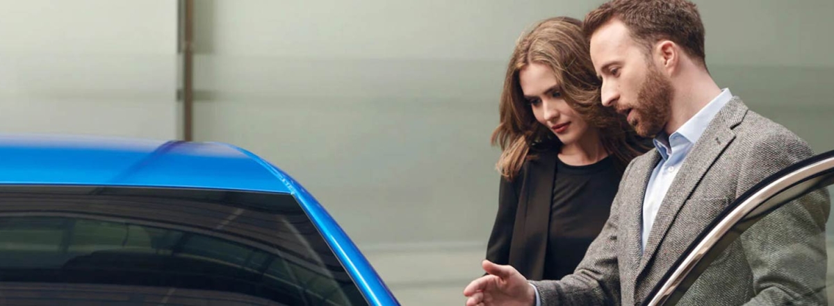 Man and lady looking inside new Peugeot 2008