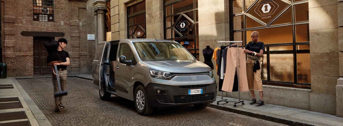 Silver Fiat Doblo with men loading a clothing rack