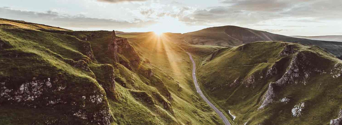 mountain road with a sunset in the background