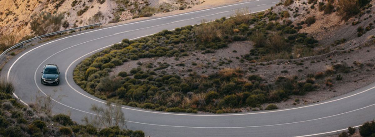 Black car driving down winding road