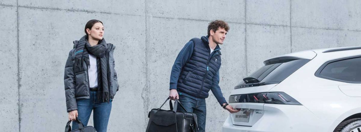Couple opening the boot of a white Peugeot 508 SW