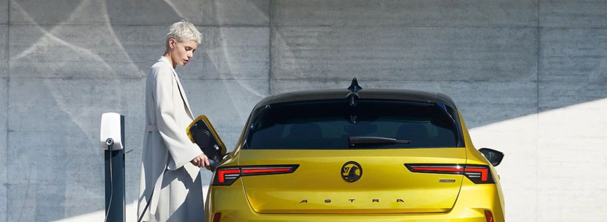 Lady charging Vauxhall Astra in Electric Yellow