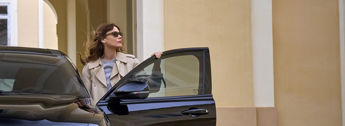 A lady standing in an open door of an Alfa Romeo Tonale, with one hand resting on the top of the door.