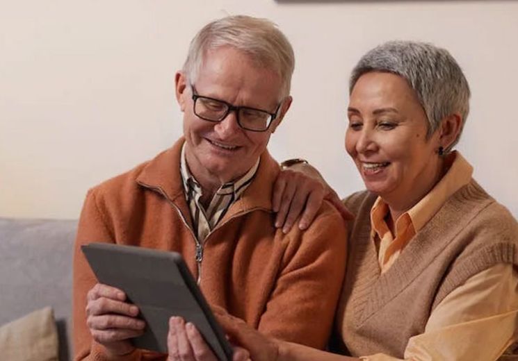 Couple sitting on the sofa with a tablet