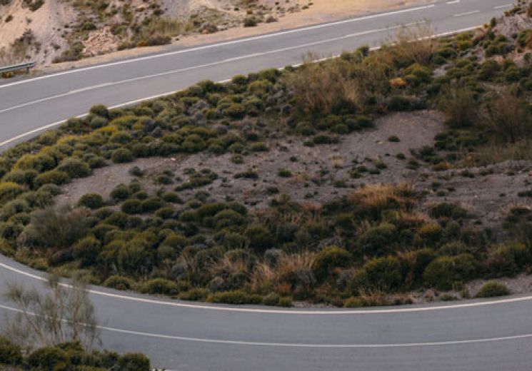 Black car driving down winding road