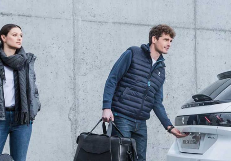 Couple opening the boot of a white Peugeot 508 SW