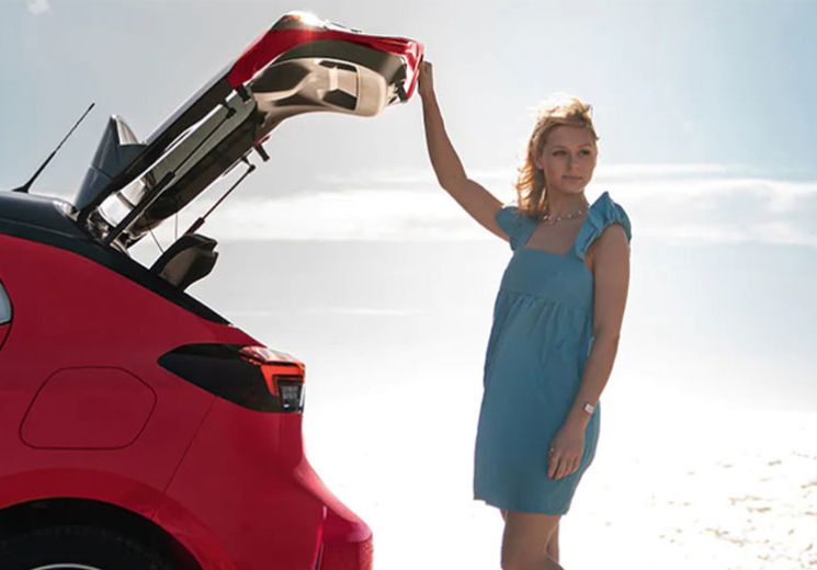 lady opening boot of vauxhall corsa on a beach
