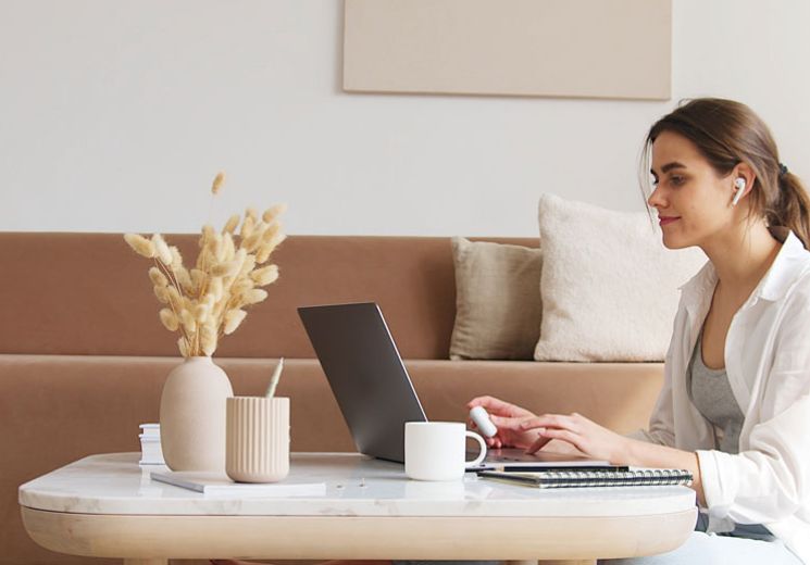 Lady sitting on the floor with her laptop on a coffee table