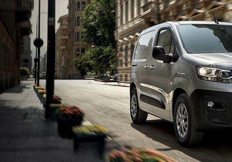 Fiat Doblo in silver driving through city