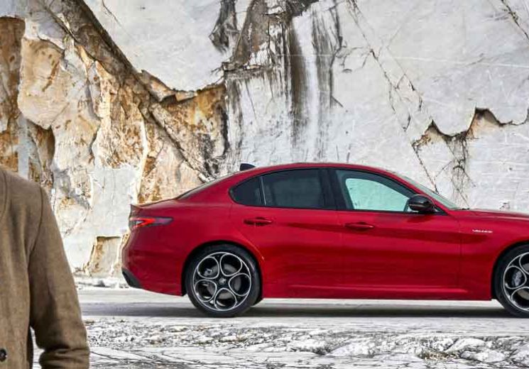 Man walking away from red Alfa Romeo Stelvio