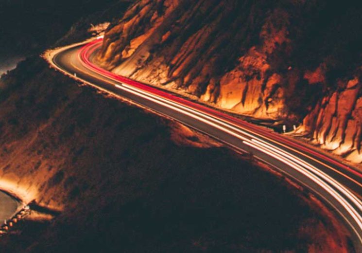 Moving lights on mountain road at night time