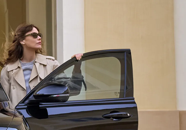 A lady standing in an open door of an Alfa Romeo Tonale, with one hand resting on the top of the door. 