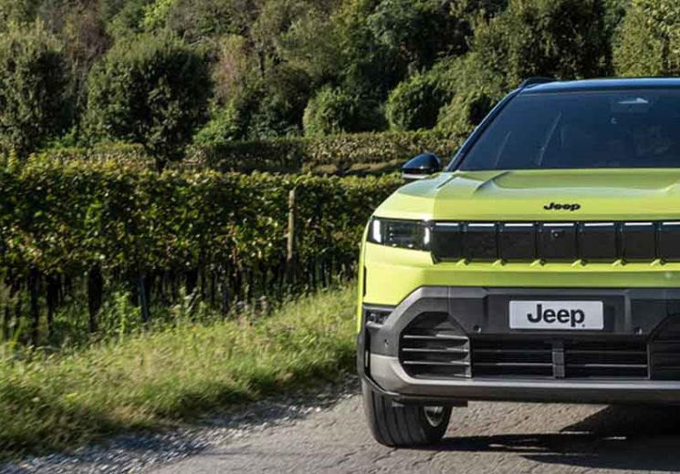 Hawaii green Jeep Compass driving on a country road.