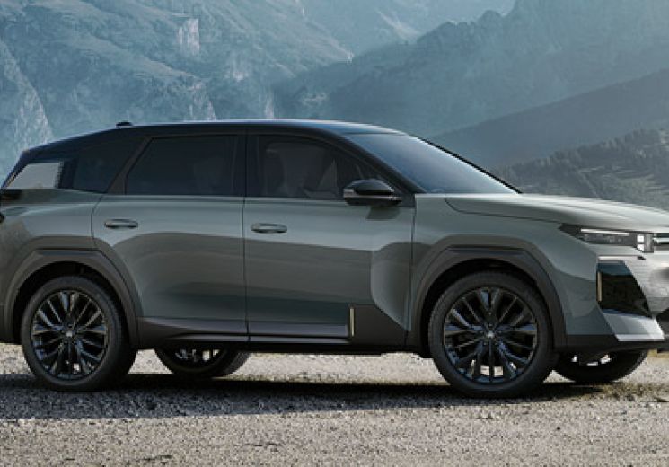 Side view of a Astoria Green Citroen C5 Aircross parked with snowy mountains in the background.