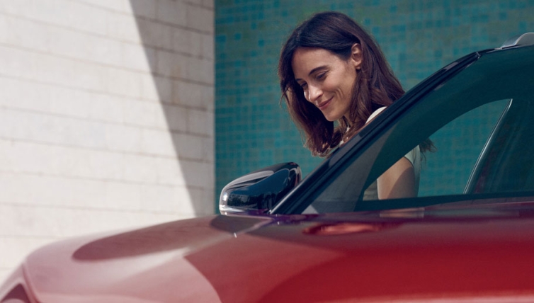 Lady standing by the side of a red car