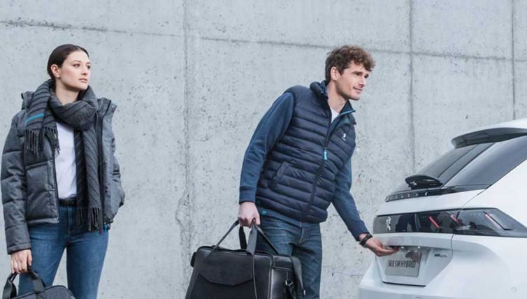 Couple opening the boot of a white Peugeot 508 SW