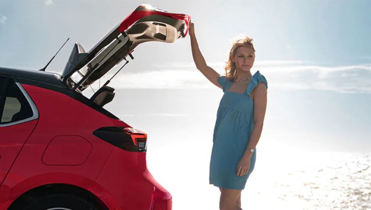 lady opening boot of vauxhall corsa on a beach