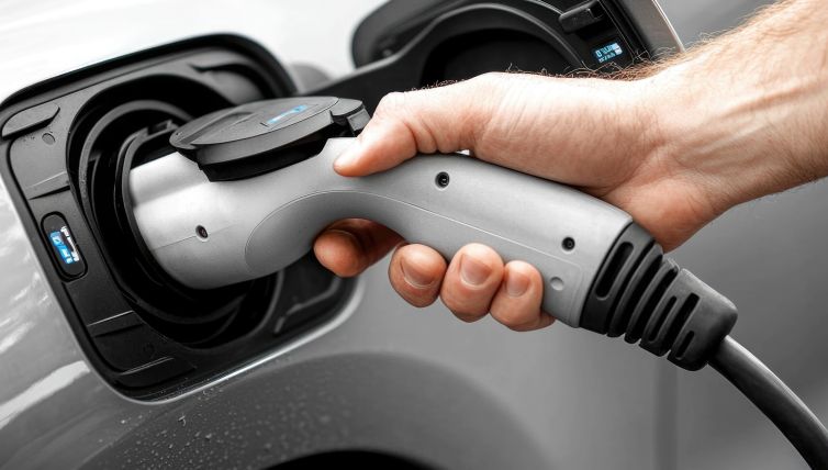 Someone plugging a charging cable into an electric car