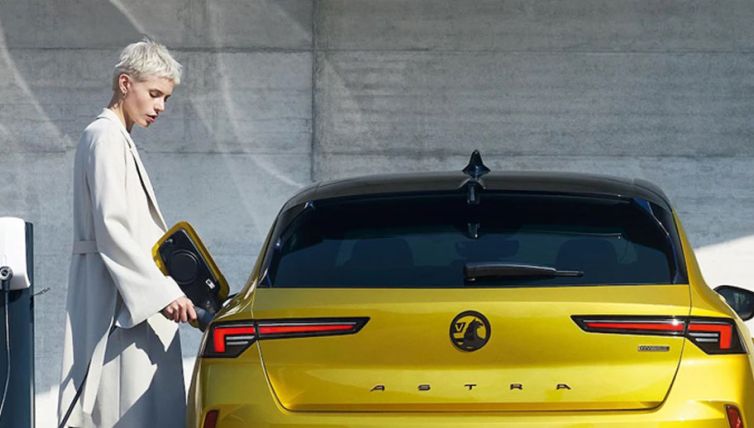Lady charging Vauxhall Astra in Electric Yellow
