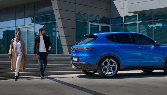 Couple walking away from Alfa Romeo Tonale in Blue