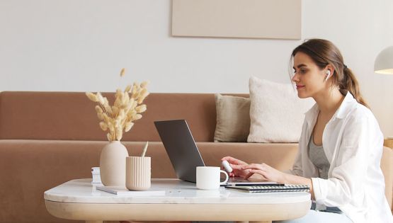 Lady sitting on the floor with her laptop on a coffee table