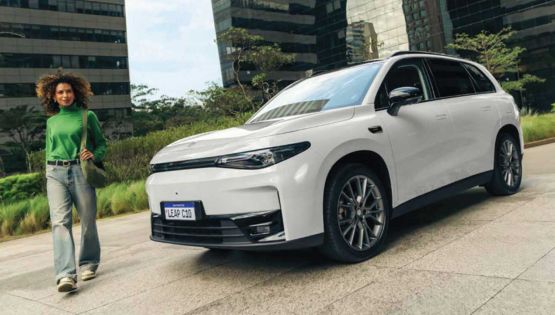 Leapmotor C10 electric SUV in Pearly White on a city street with modern architecture in the background.