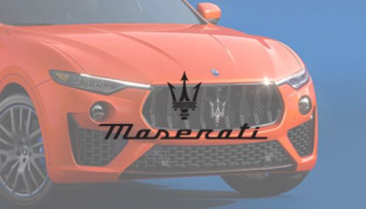 Greyscale Maserati logo with car in background