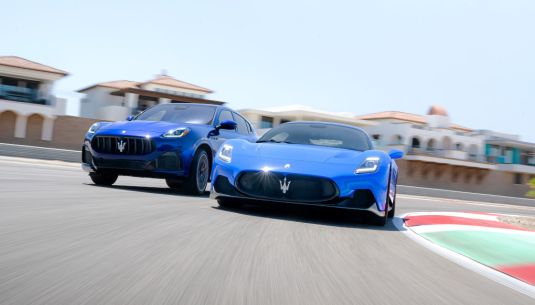 Two blue Maserati's on a race track