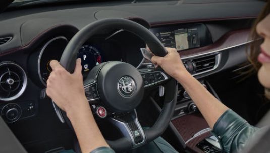 Interior view of an Alfa Romeo Stelvio with a person in the driver's seat.