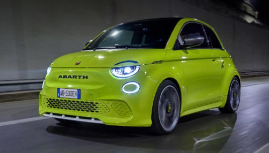 Green Abarth 500e driving through a tunnel.