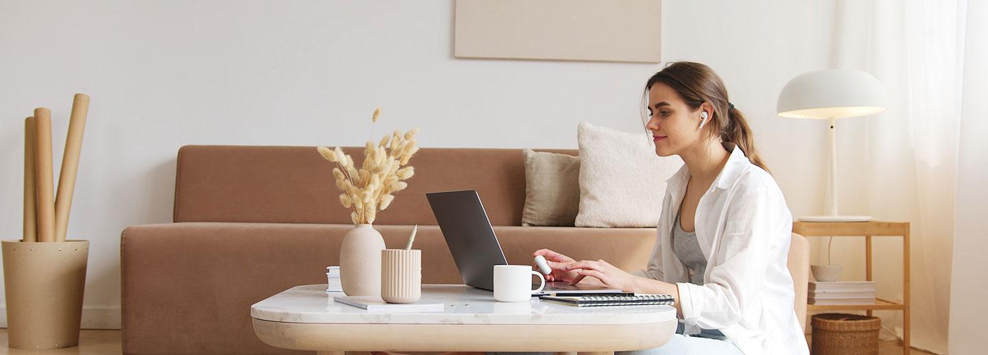 Lady sitting on the floor with her laptop on a coffee table