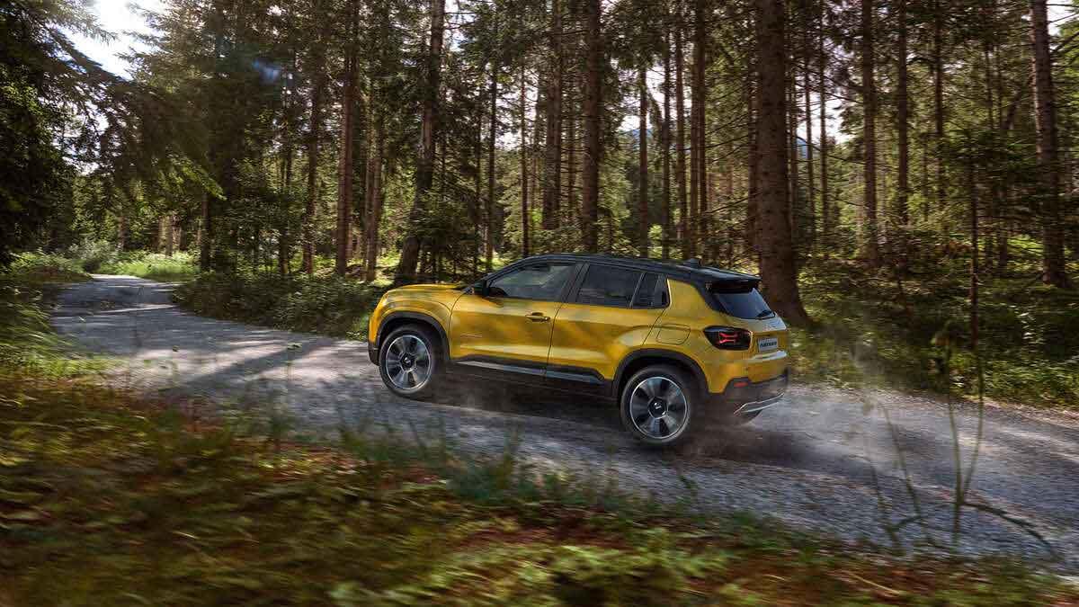 Yellow Jeep Avenger driving through forests of pine trees