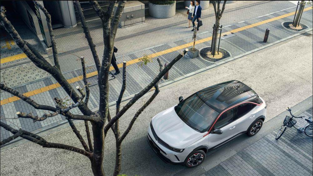 White Vauxhall parked in a paved street