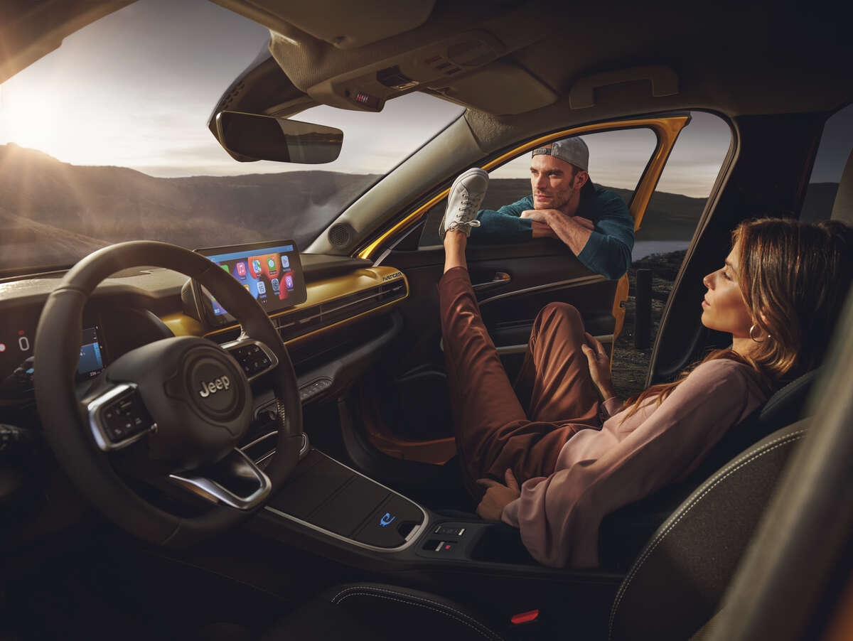 Couple sitting inside a parked yellow Jeep Connettivita