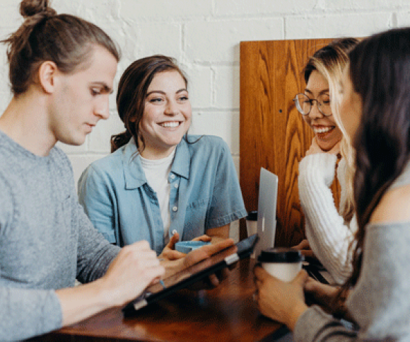 A young group smiling together whilst working